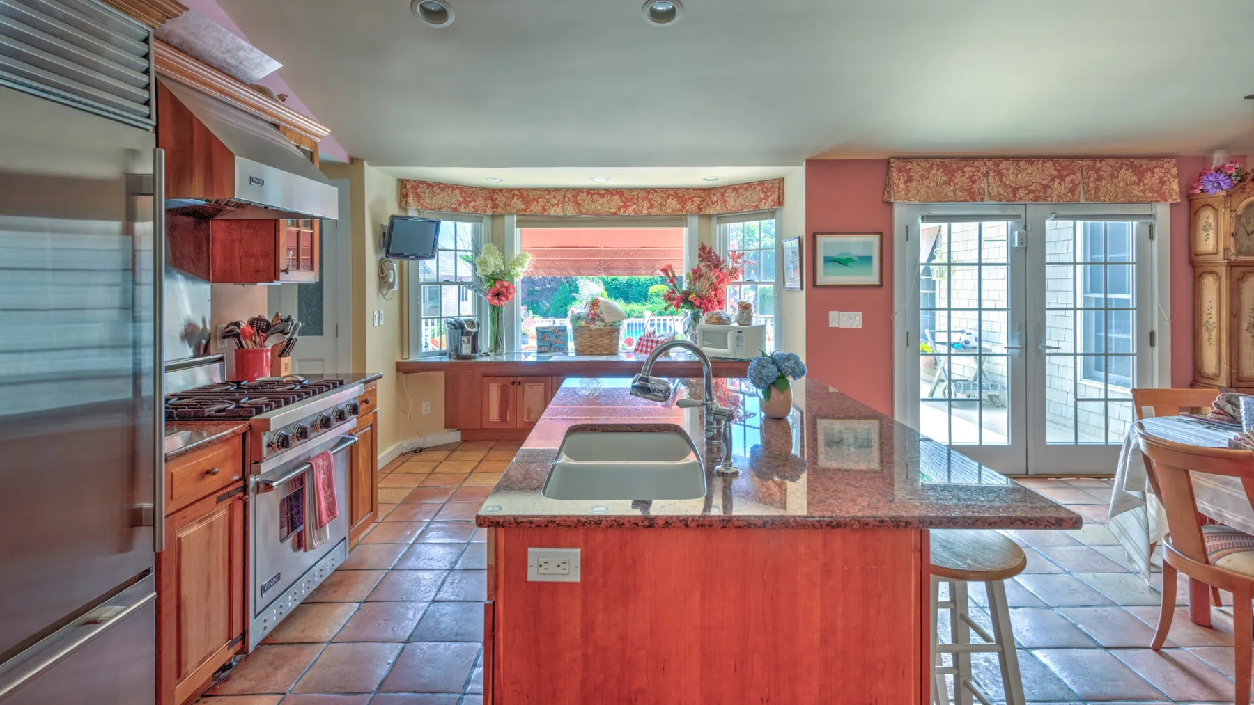 Una cocina luminosa con una isla central y puertas de vidrio que dan a un patio.