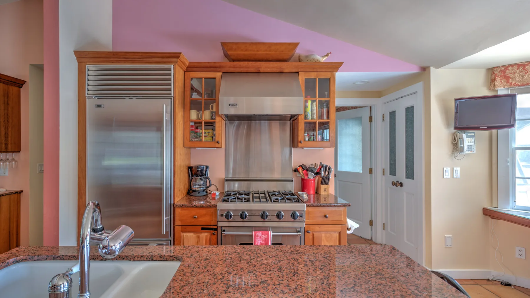 Una cocina con gabinetes de madera, una estufa de acero inoxidable y una amplia encimera.