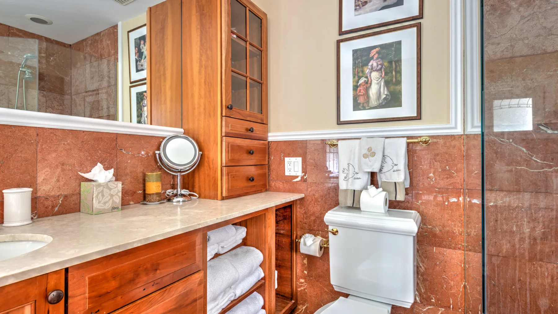 Un lavabo de baño con armarios de madera y un inodoro.