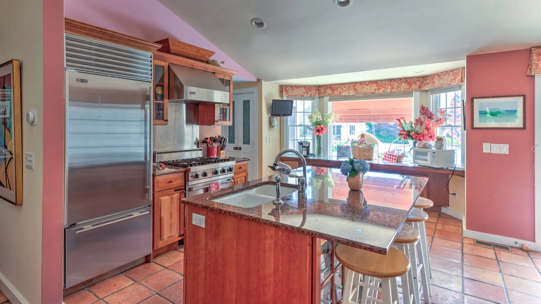 Una cocina luminosa con una isla central y una amplia ventana con vista al patio.