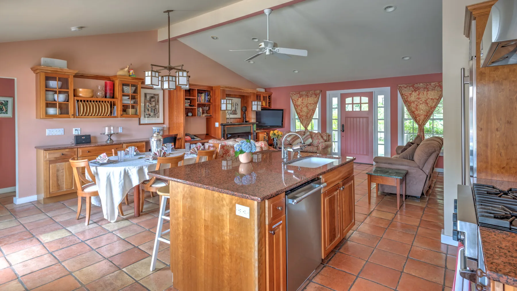 Una cocina abierta con comedor, una isla grande y gabinetes de madera.