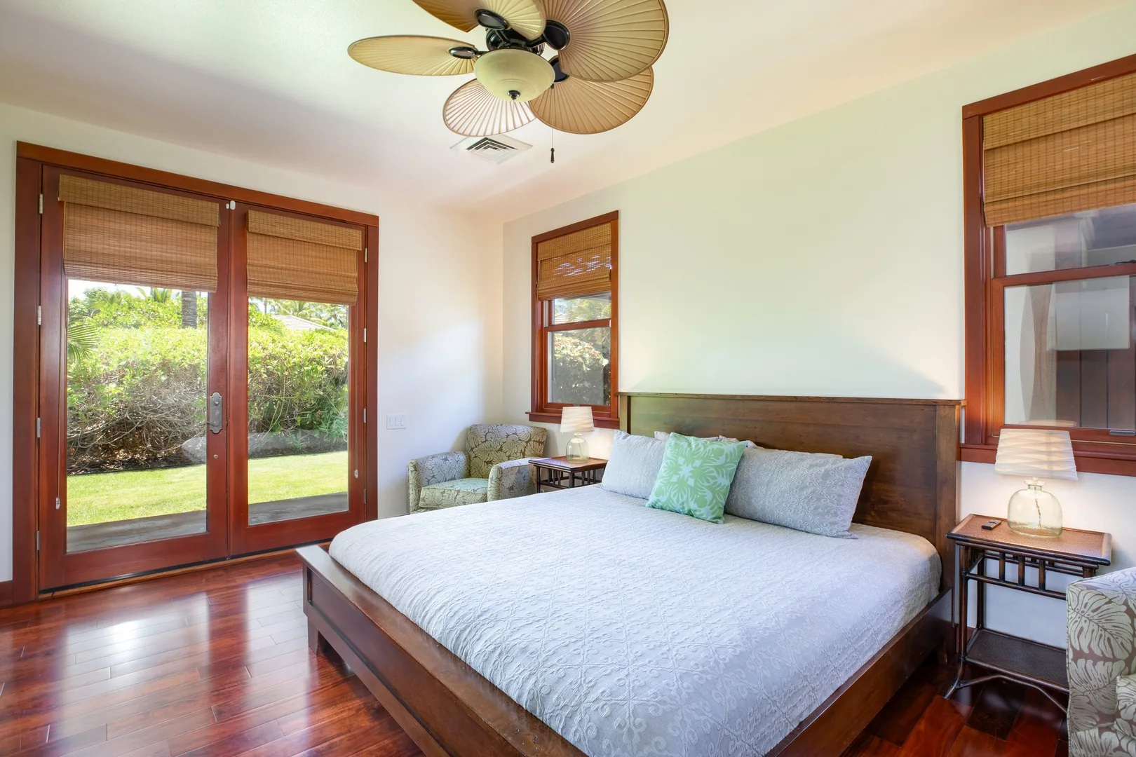 Un dormitorio luminoso con una cama grande y puertas de vidrio que dan a la vegetación.