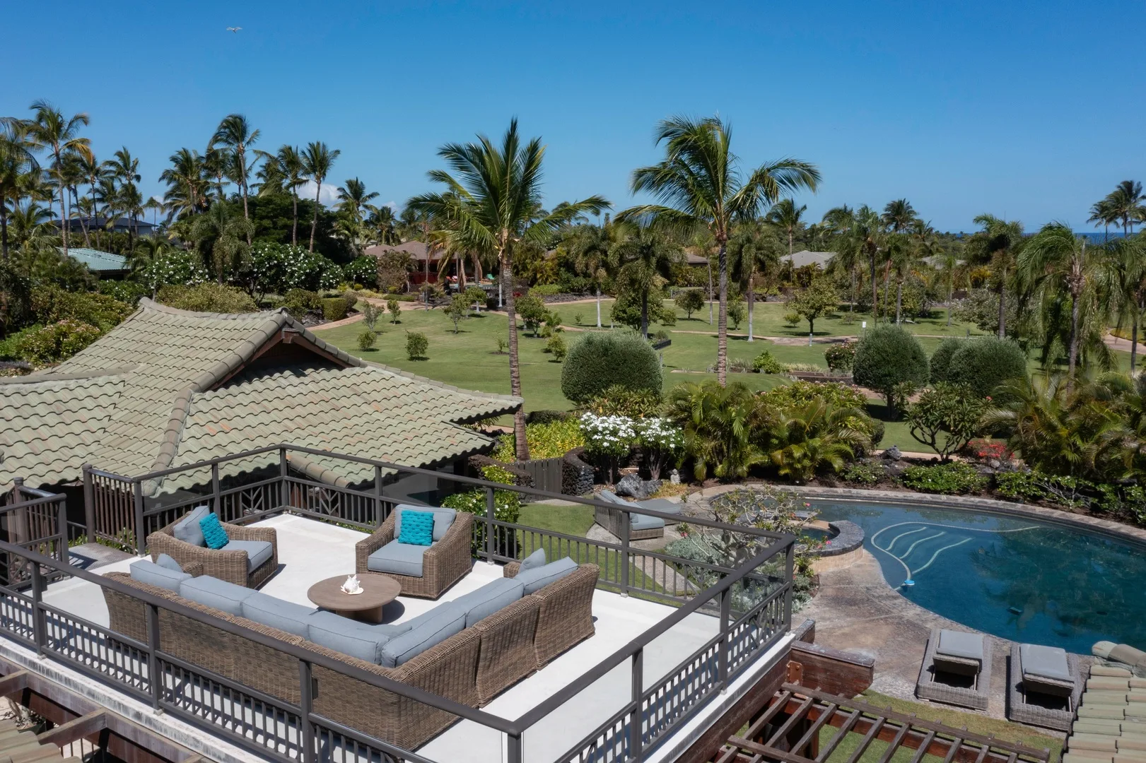 Una zona de estar al aire libre da a una piscina y jardines.