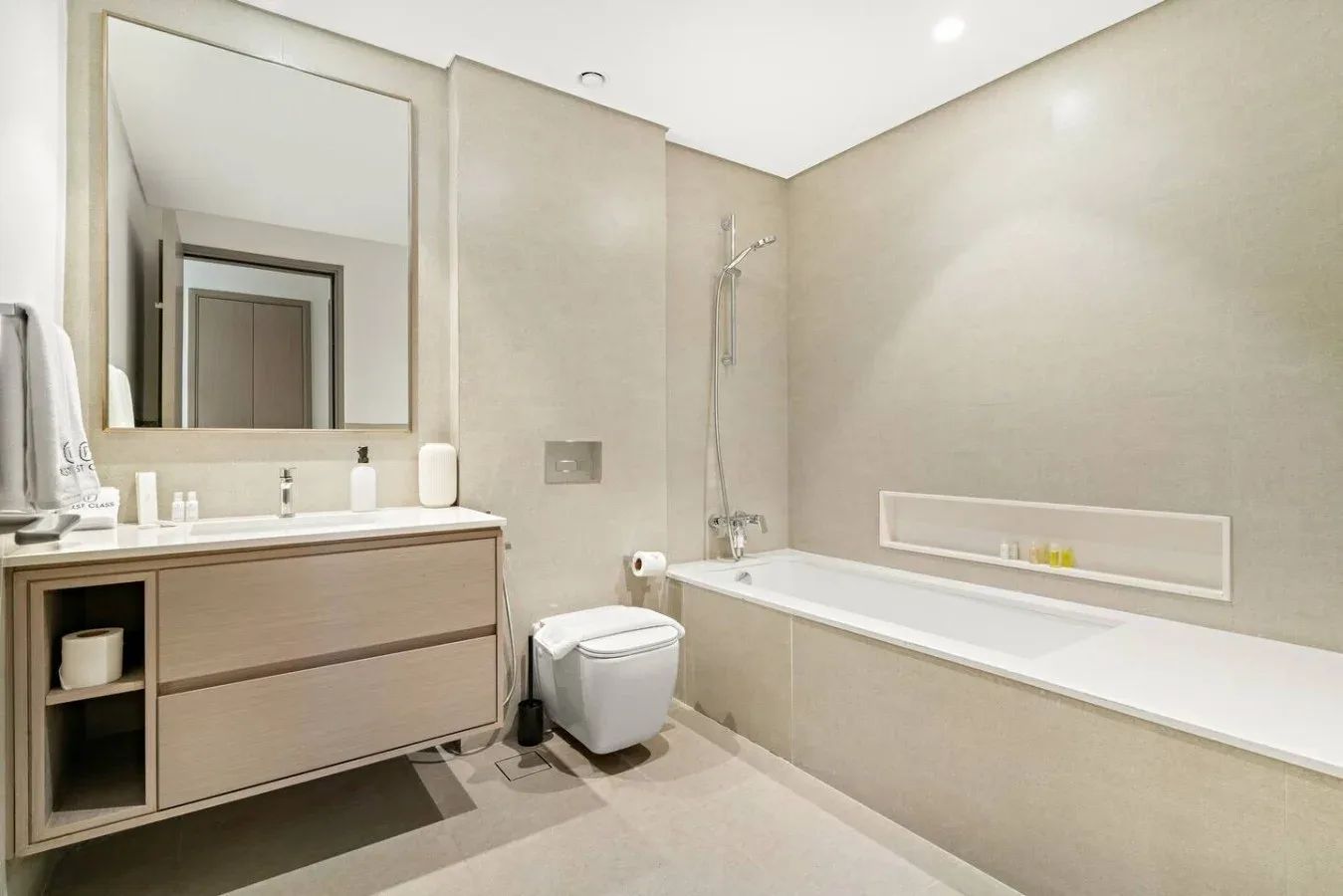 Un baño luminoso con bañera, lavabo e inodoro.