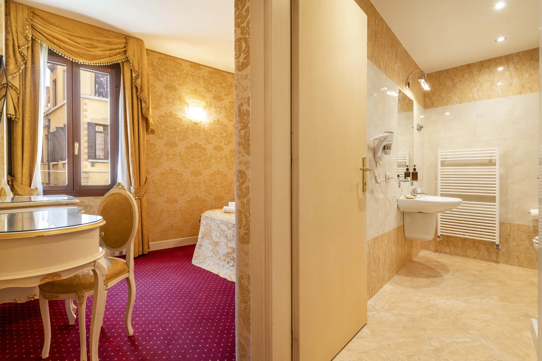 A bedroom and adjoining bathroom with patterned walls and a window.