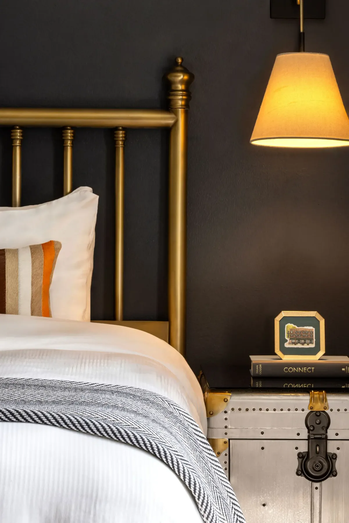 Dormitorio con cama de latón y lámpara de noche