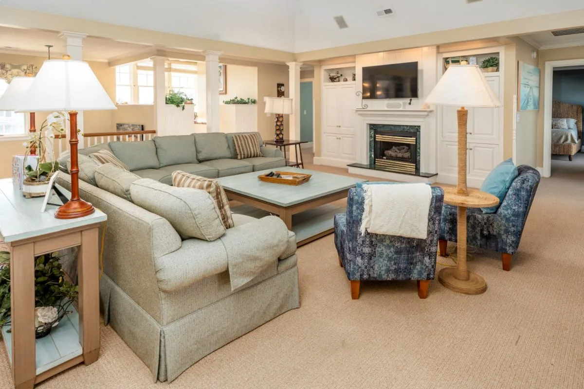 A living room with a sectional sofa, coffee table, and fireplace.