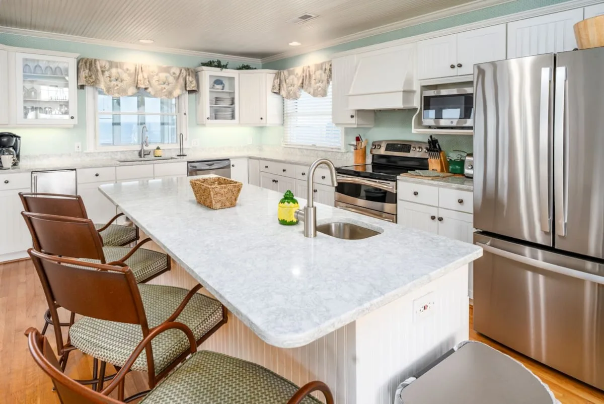 A bright kitchen with white cabinetry and a large central island.