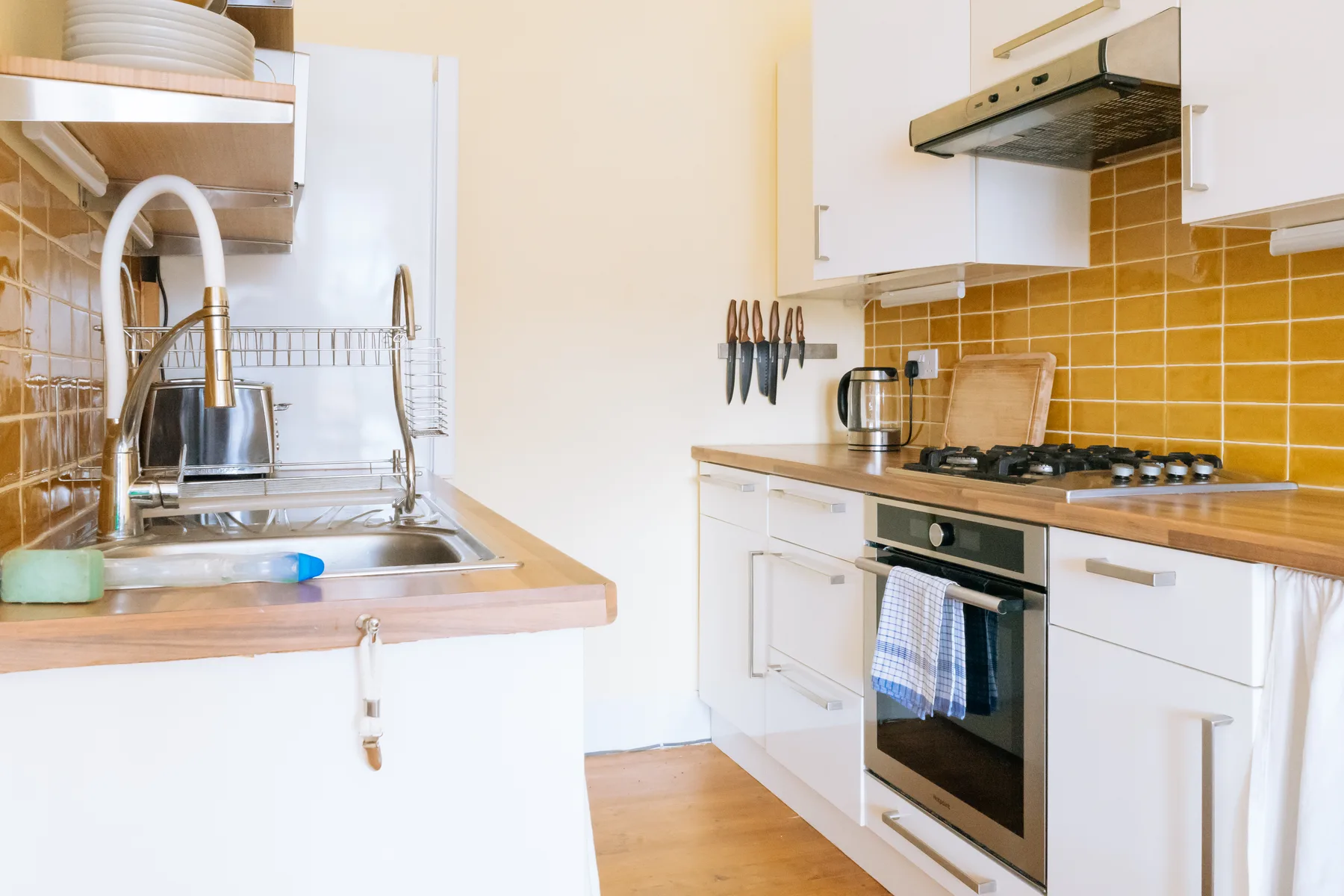 Una cocina luminosa con un fregadero y una placa de cocina junto a la encimera.