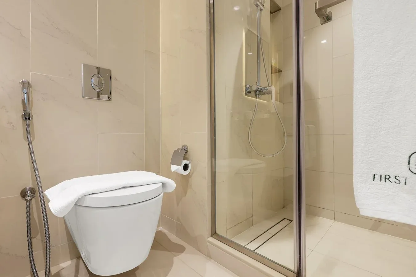 Un baño alicatado con un inodoro y una ducha de cristal.