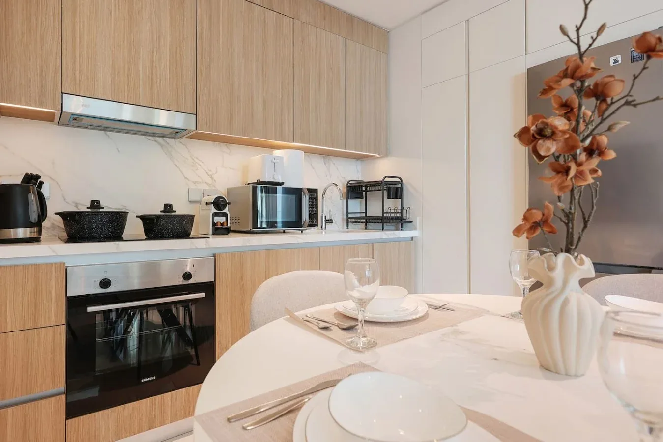 Una cocina moderna con gabinetes de madera y una mesa puesta con platos.