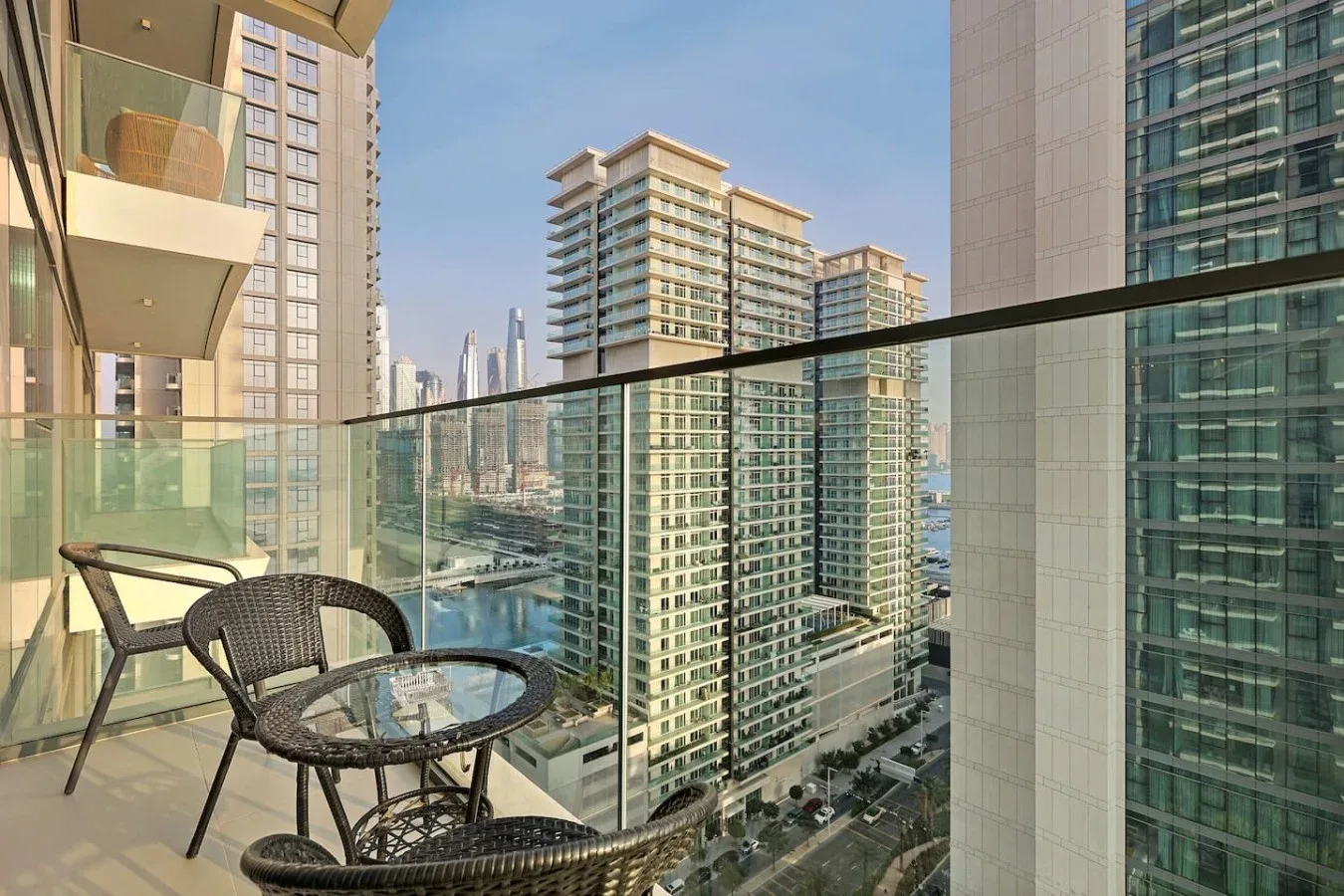 Un balcón con asientos tiene vistas a edificios altos cercanos.