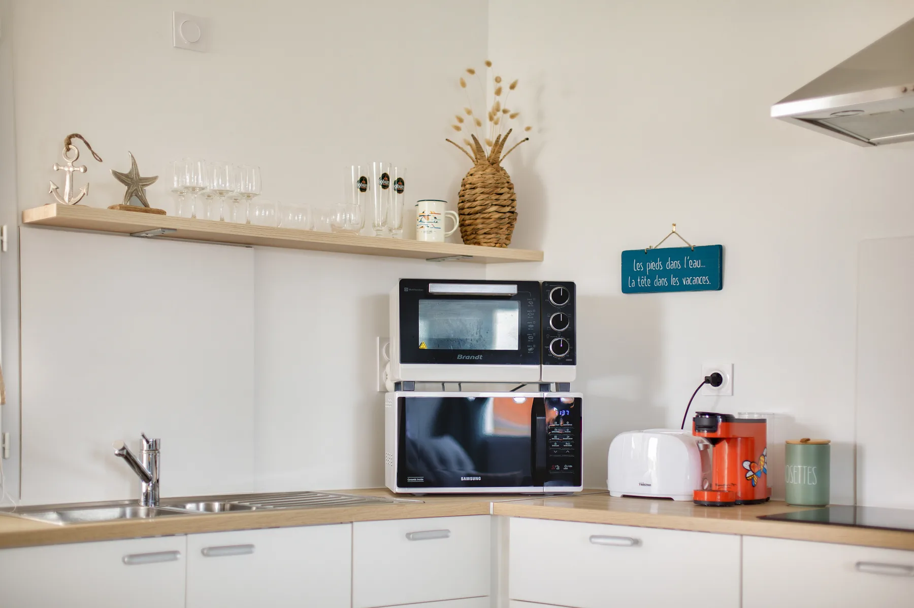 A compact kitchen with a microwave, toaster, and countertop appliances.