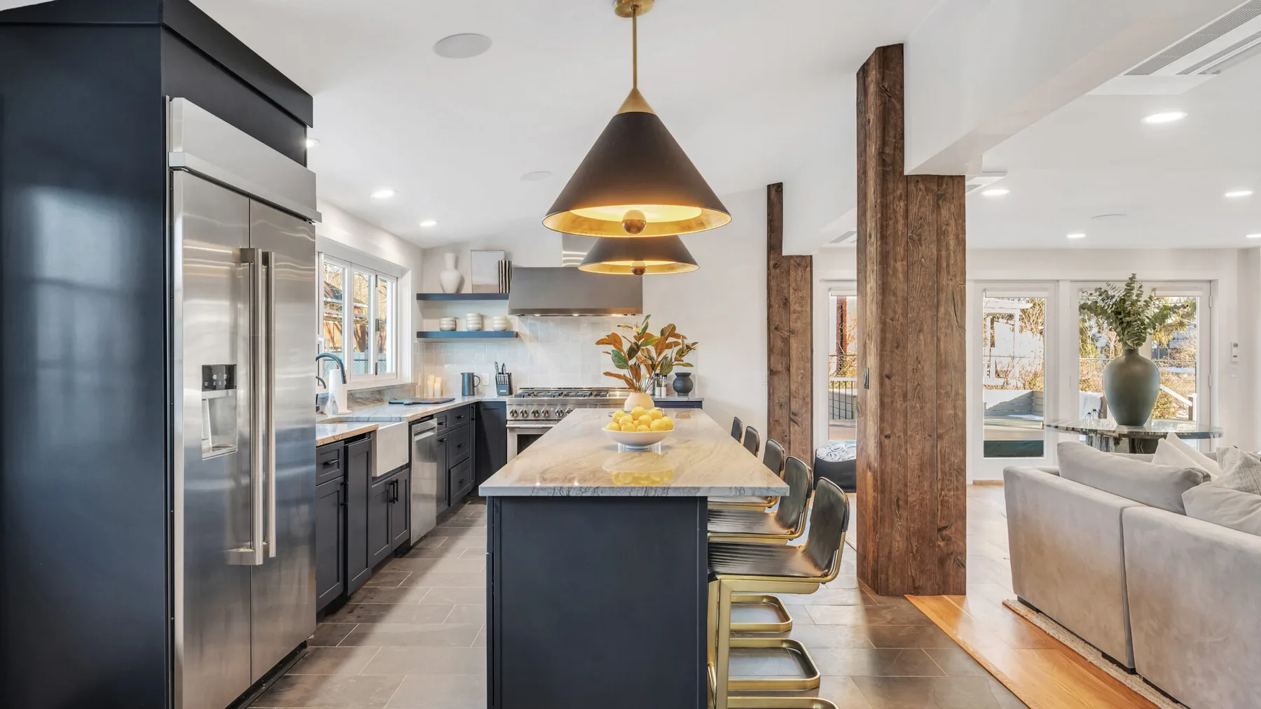 A modern kitchen with a central island and pendant lights.