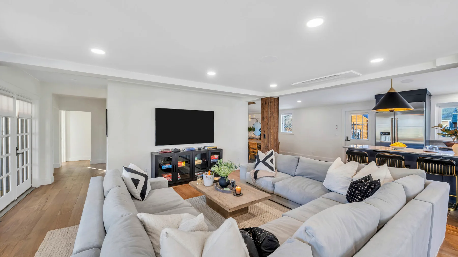 Open-plan living room with sectional seating and a dining area.