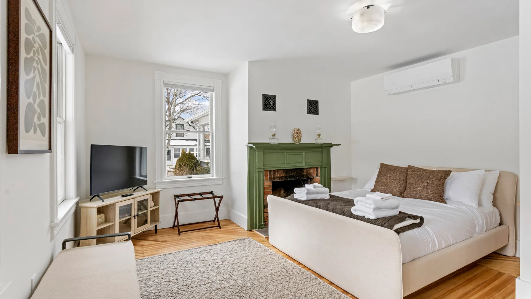 Bedroom with a large bed, fireplace, and television.