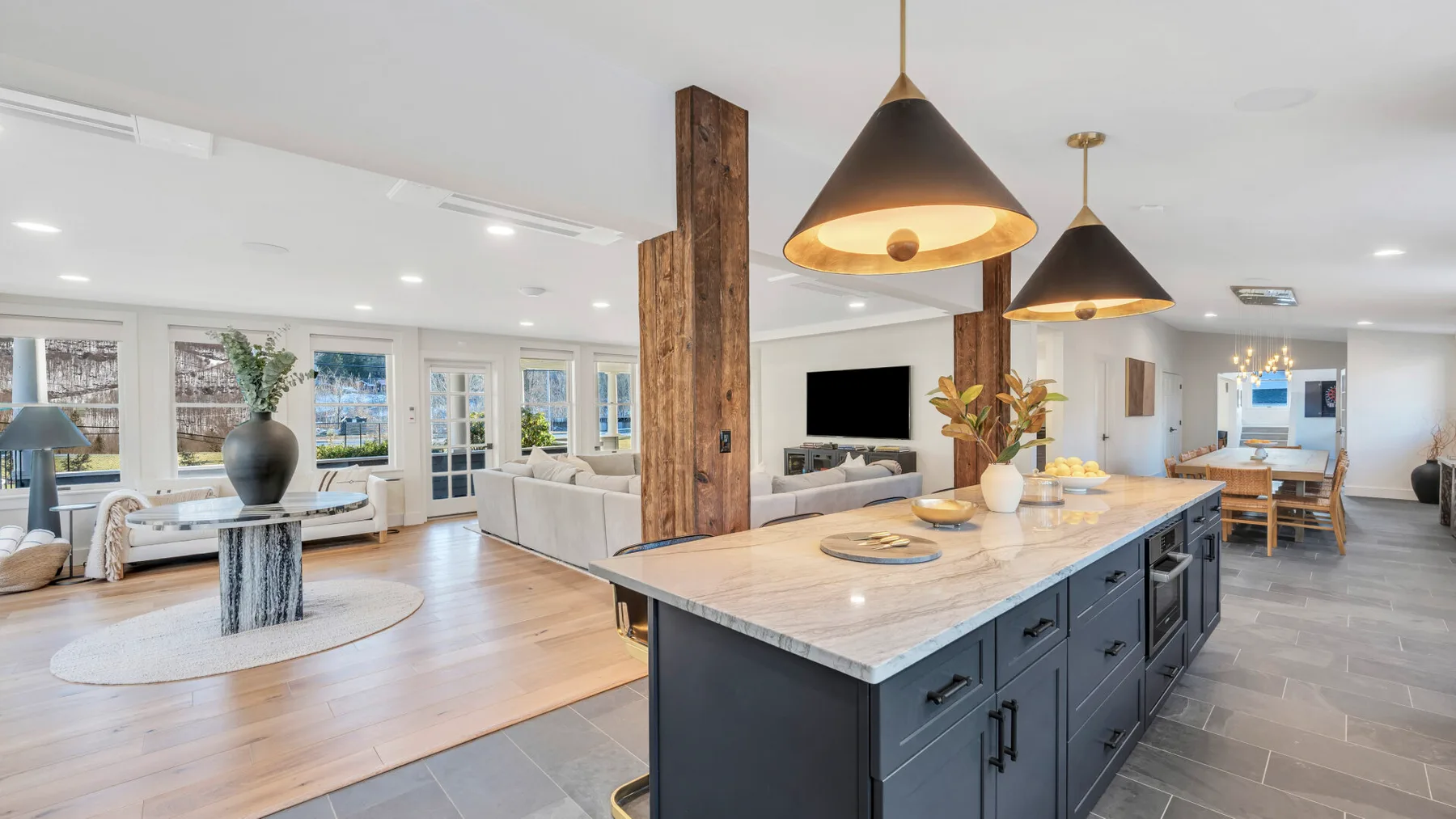 An open-plan kitchen and living area with a large island and pendant lights.