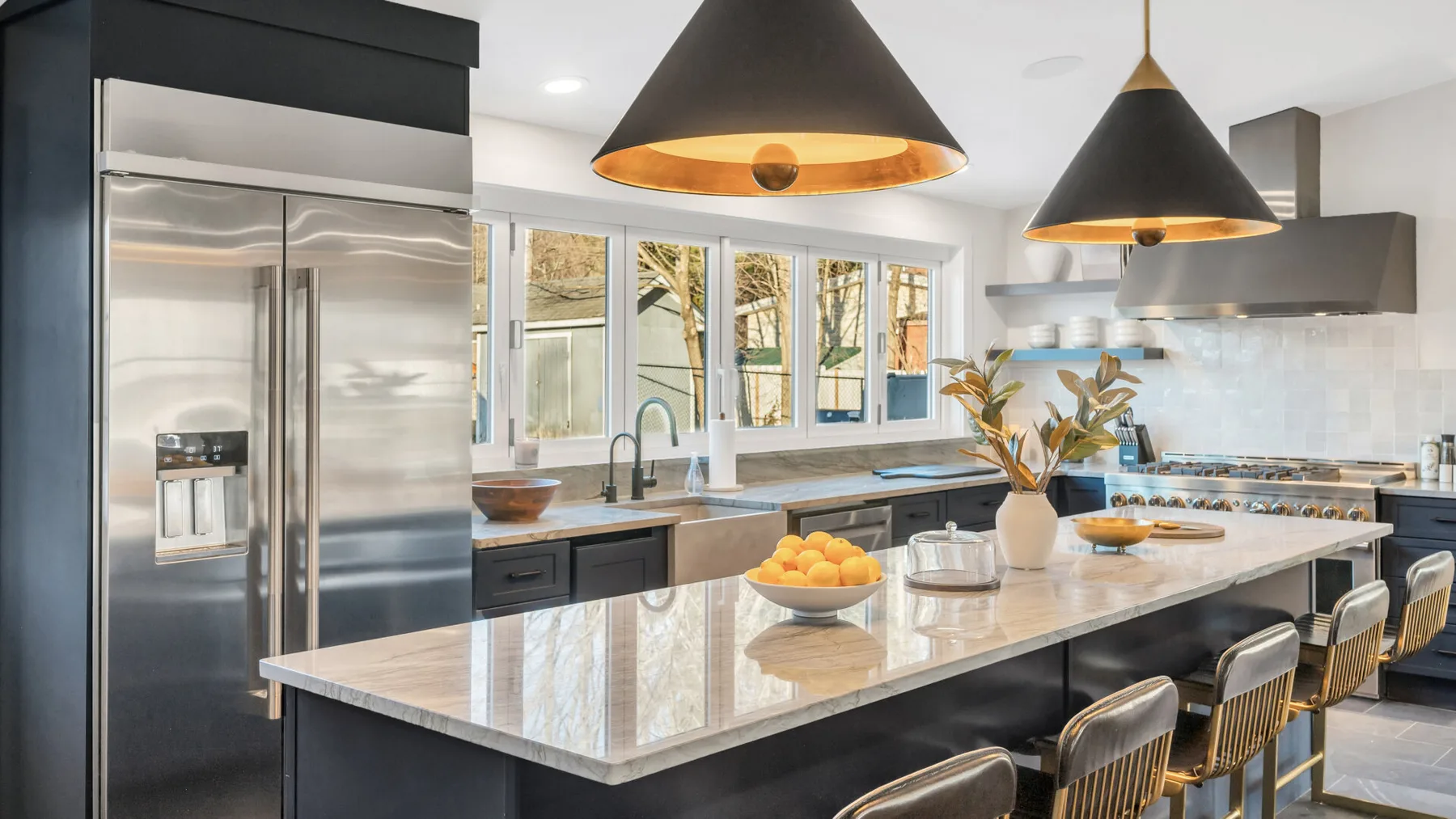 A modern kitchen with a large island and stainless steel appliances.