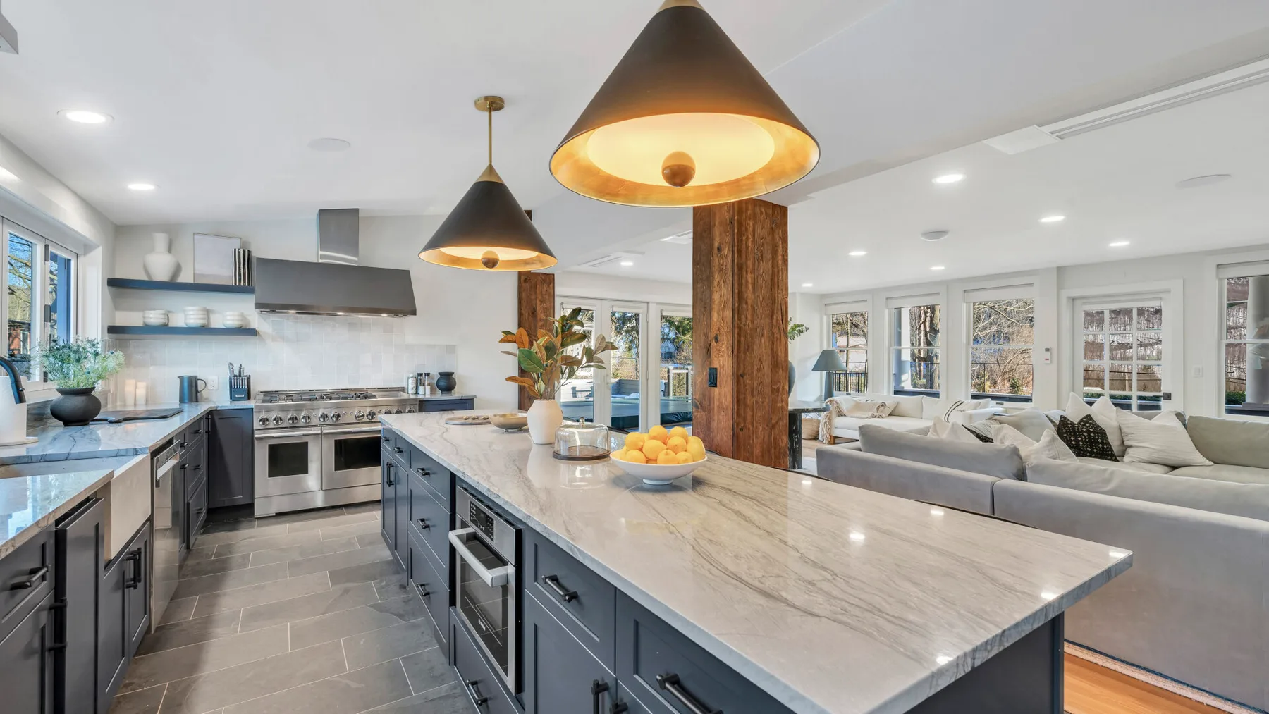 A bright kitchen with a large island and open shelving.