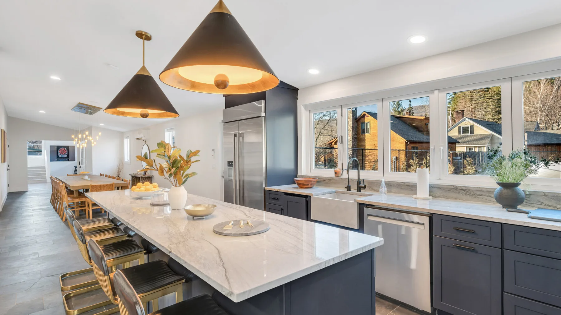 A spacious kitchen with a long island and large windows.