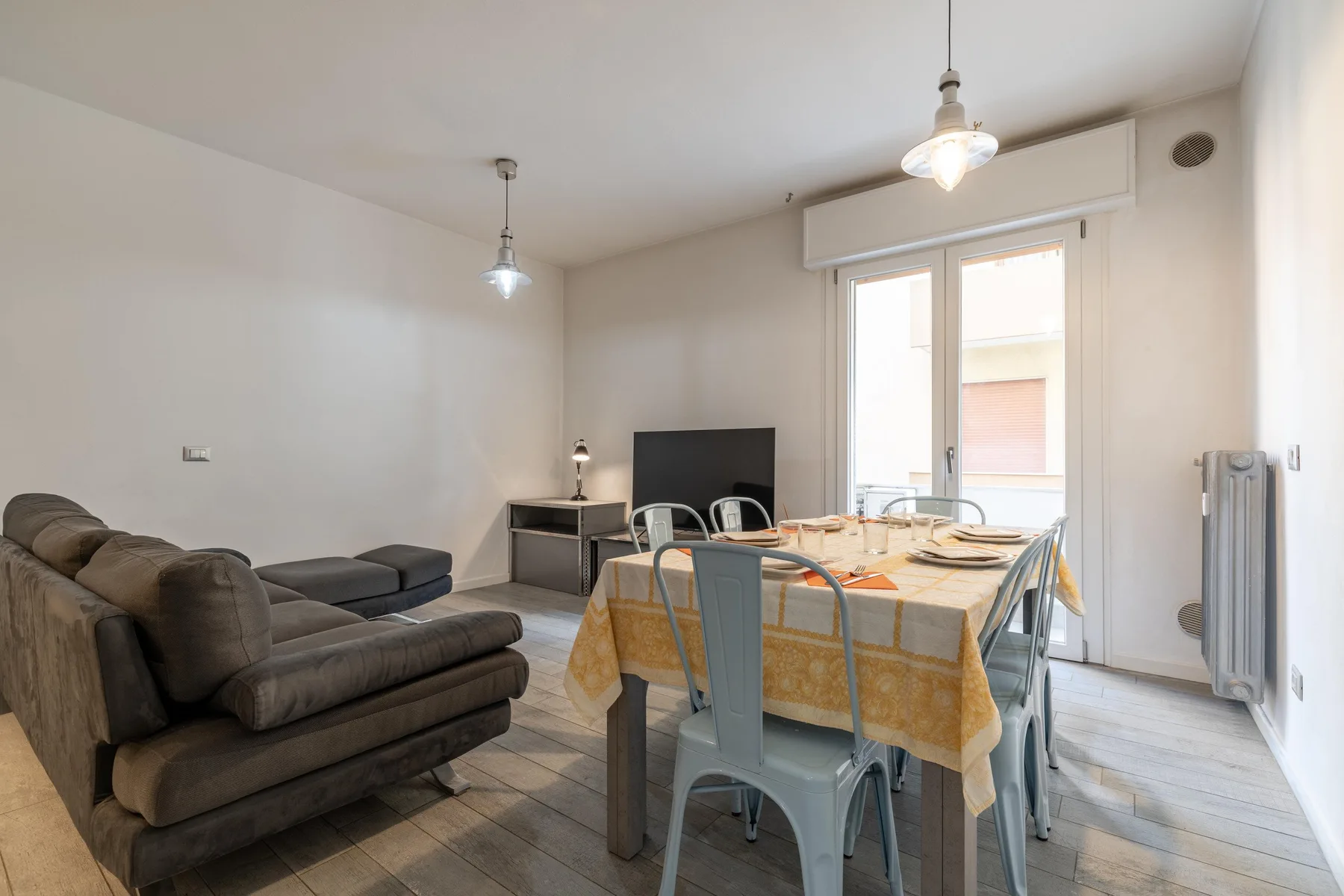Una sala de estar y comedor con mesa, sillas y televisor.
