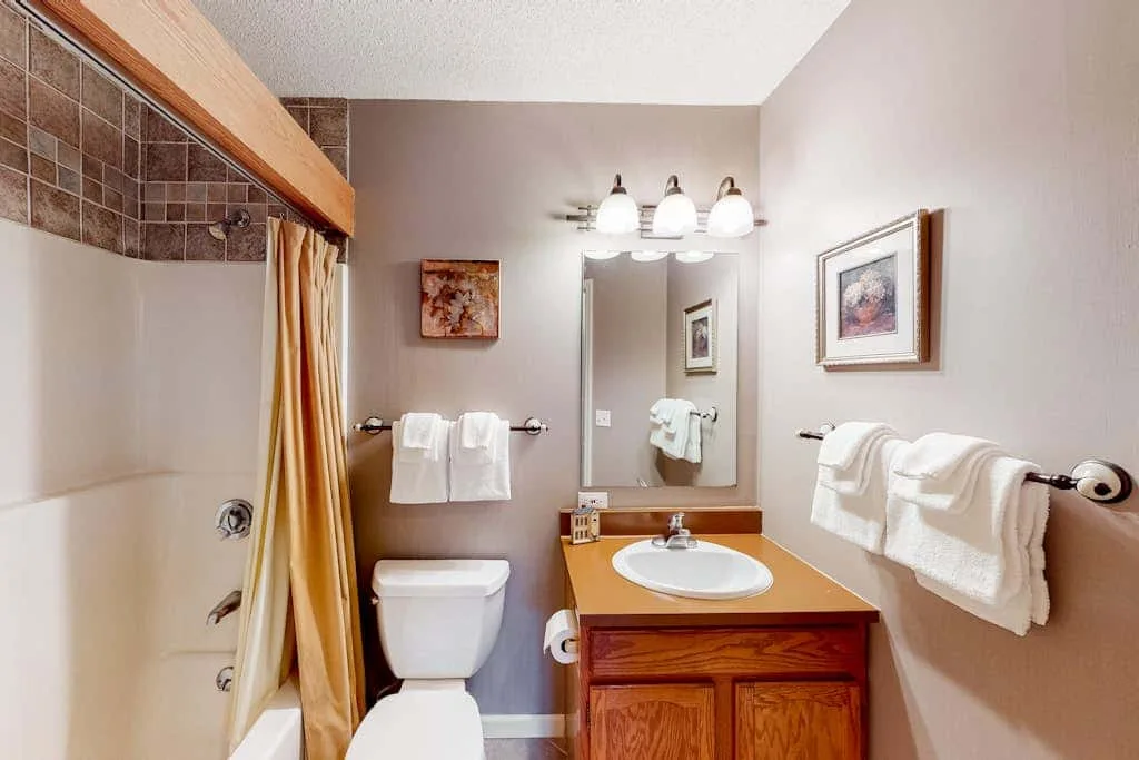 A bathroom with a vanity, sink, and shower.