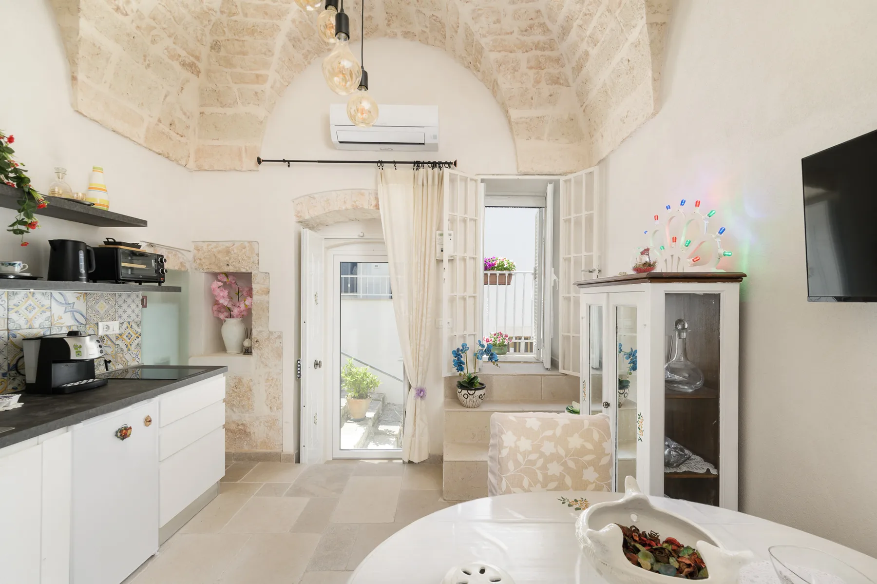 A bright kitchen and dining area with a vaulted ceiling and large windows.