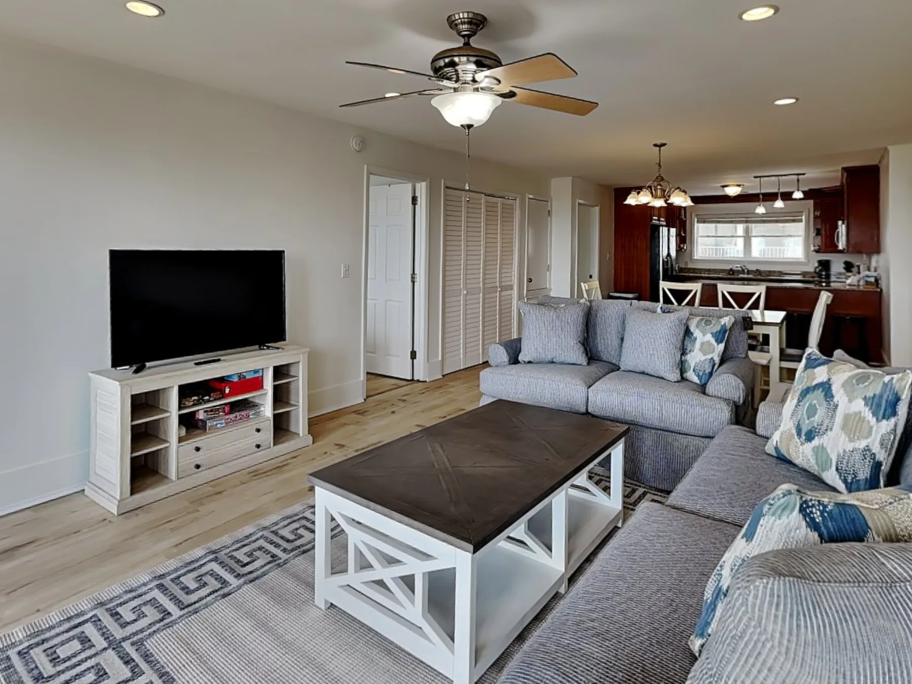 A living room with a sectional sofa, coffee table, and television.