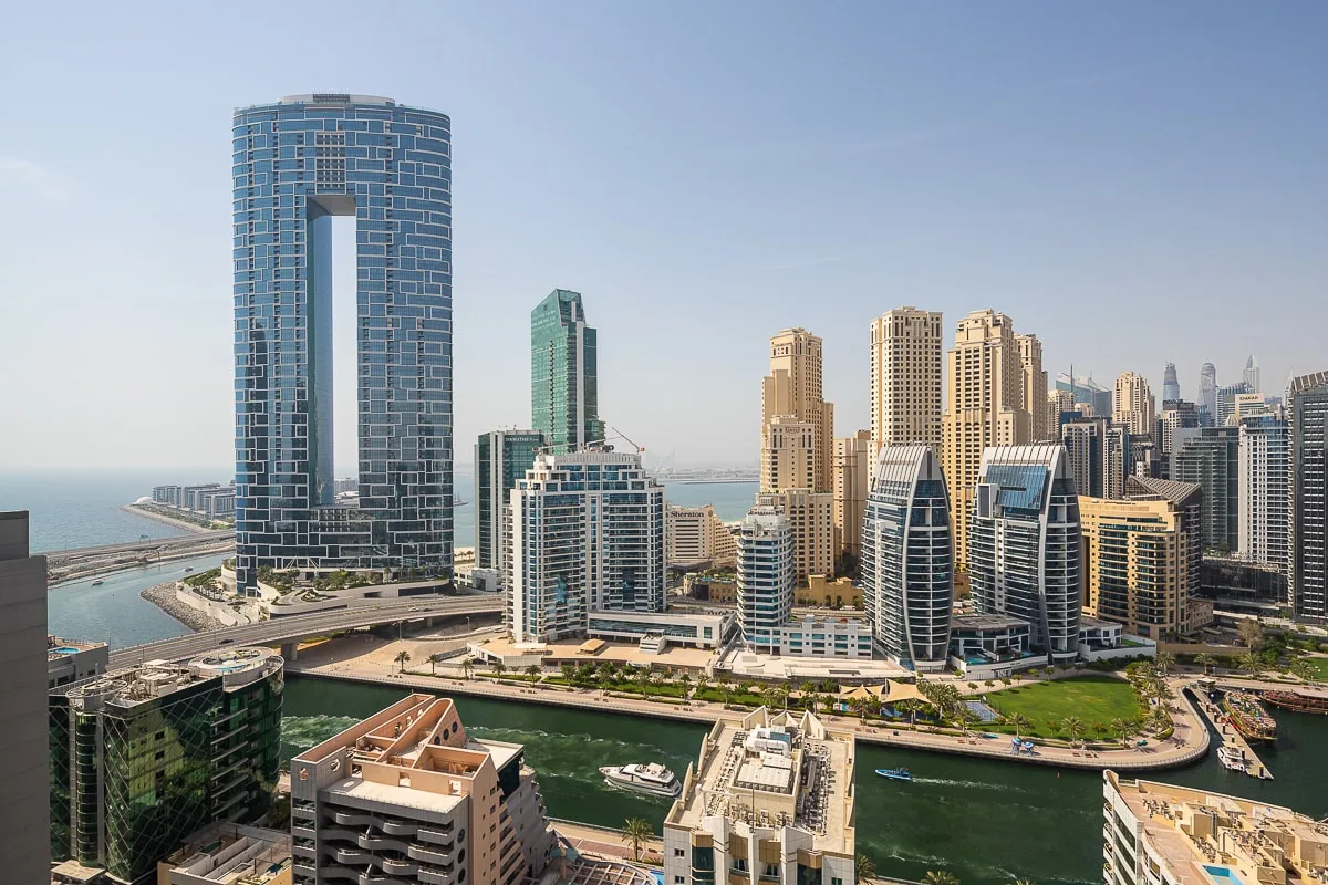 Un horizonte urbano junto al agua, con edificios altos y una marina.