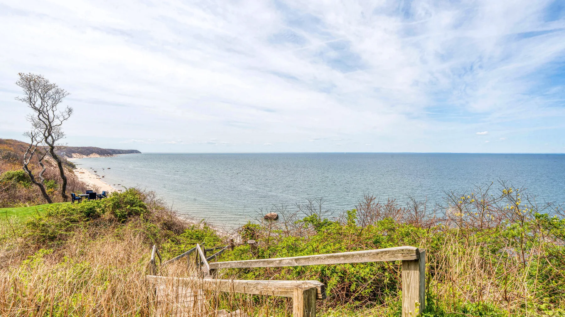 A coastal path with a wooden handrail overlooks the sea.