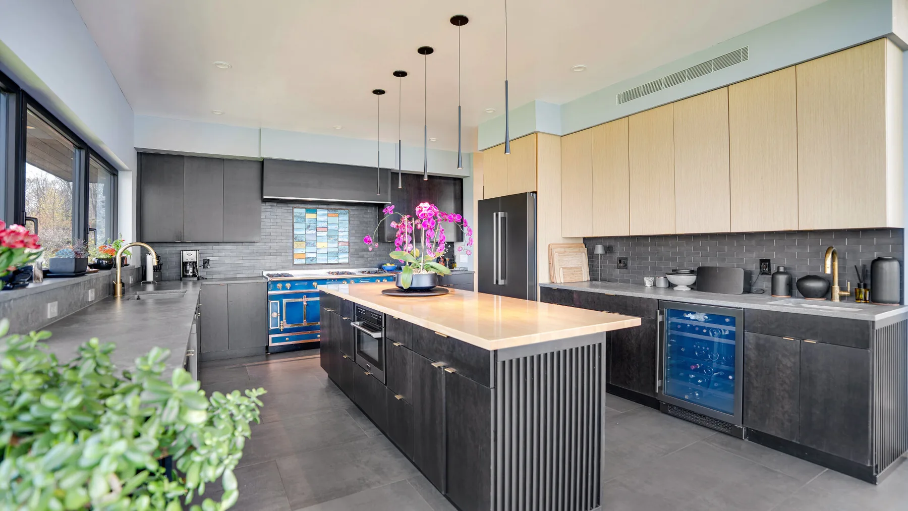 A modern kitchen with a central island and dark cabinetry.