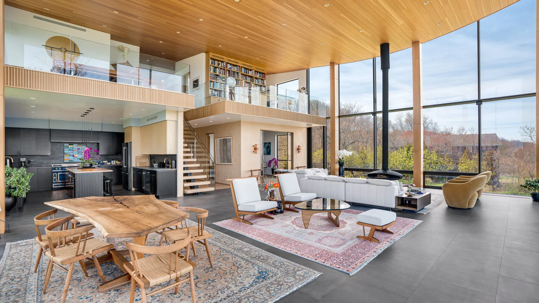 A spacious open-plan living area with seating and floor-to-ceiling windows.
