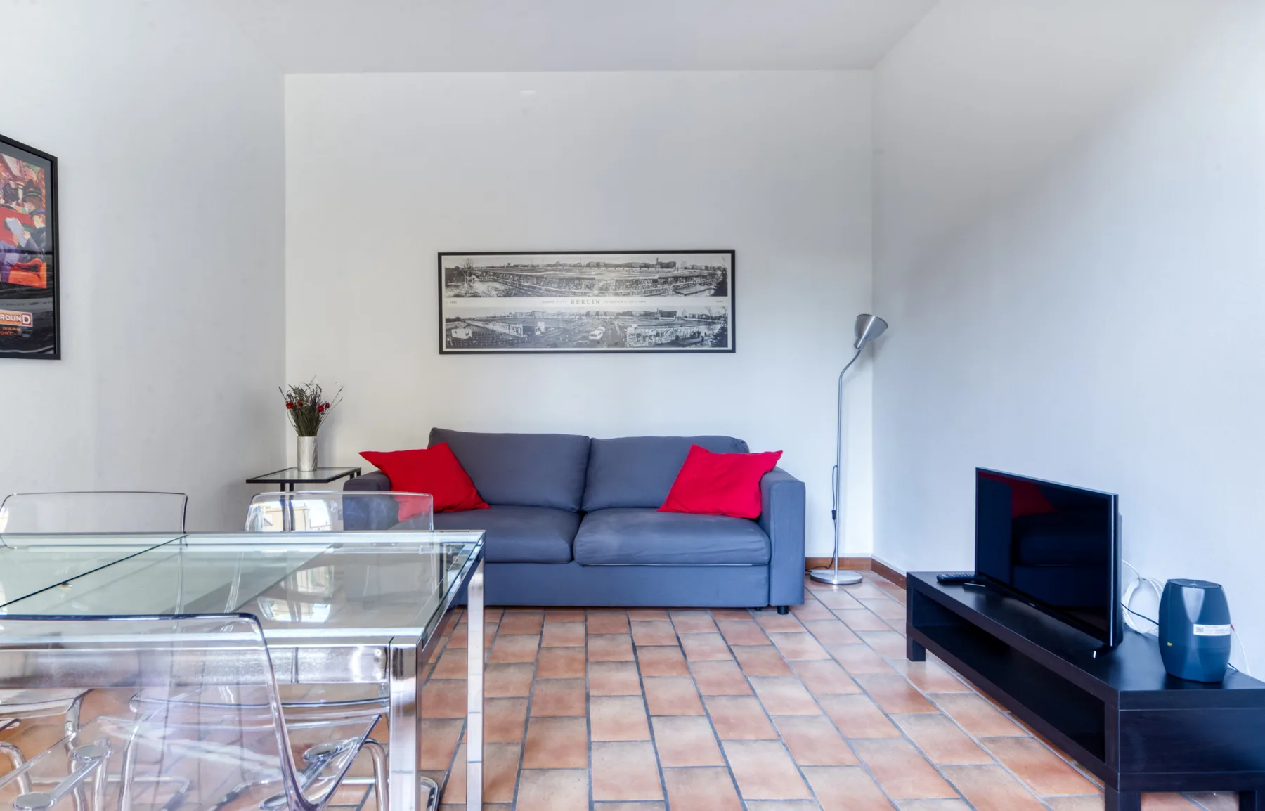 Una sala de estar con asientos azules y una mesa de centro de vidrio.