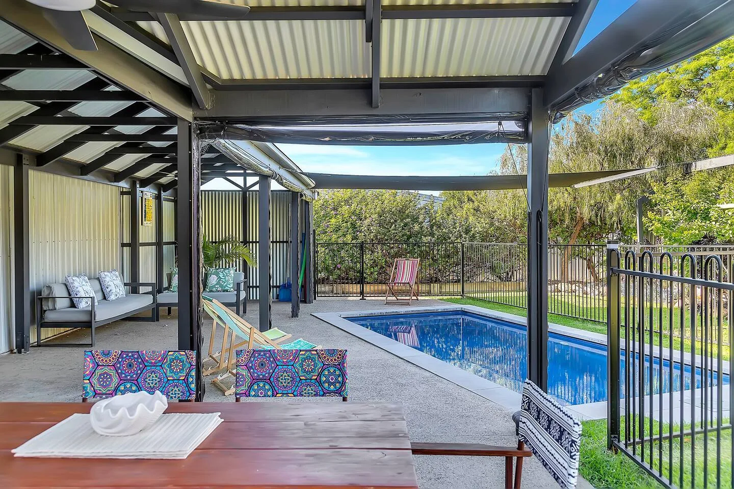 El patio trasero ofrece una zona al aire libre cubierta con vistas a la piscina.