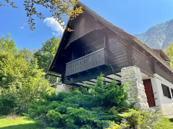 Frontón de la fachada y entrada cubierta de Red Beech Cabin a la luz del día