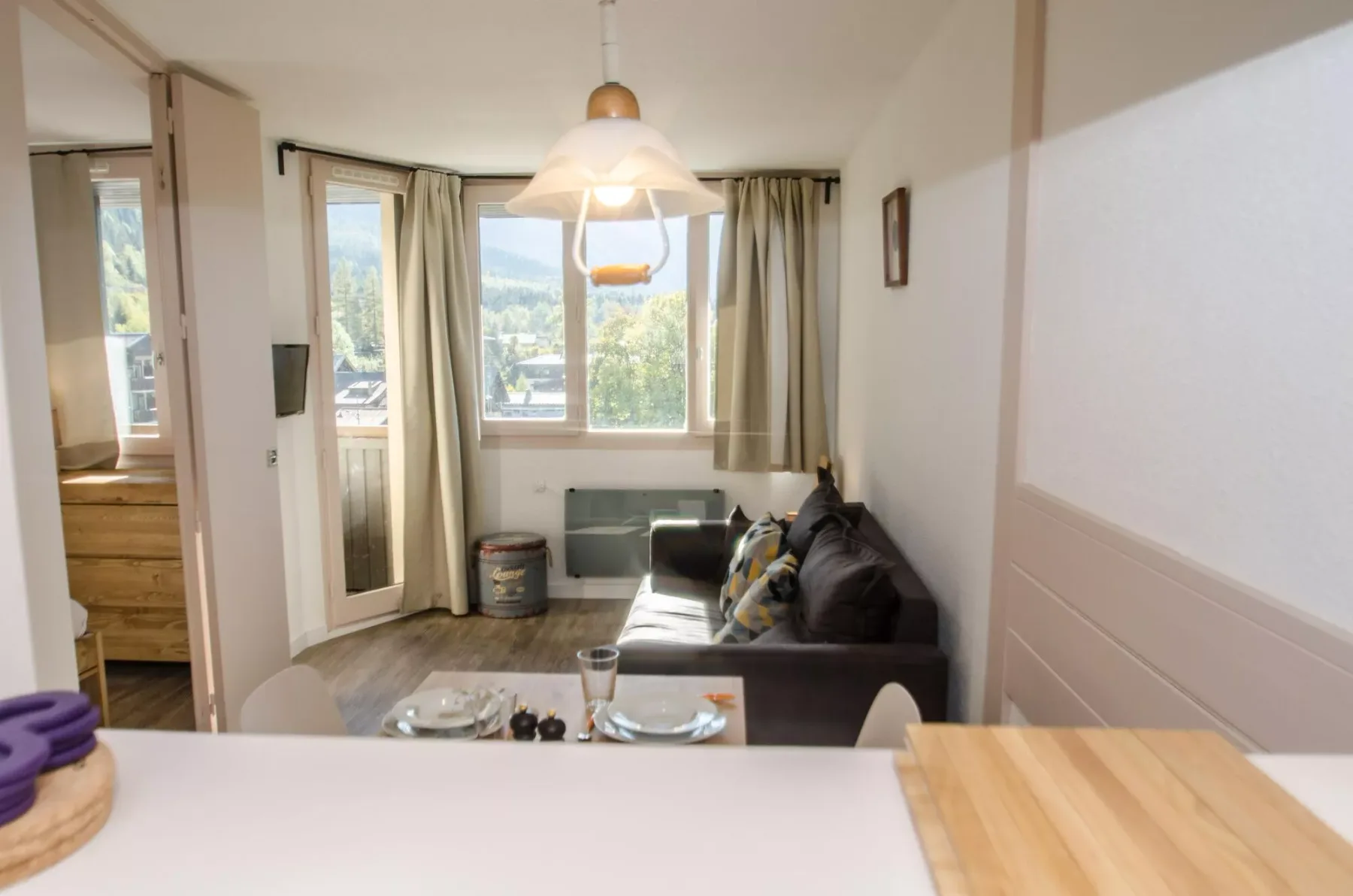 A bright living room with a sofa beside a large window.