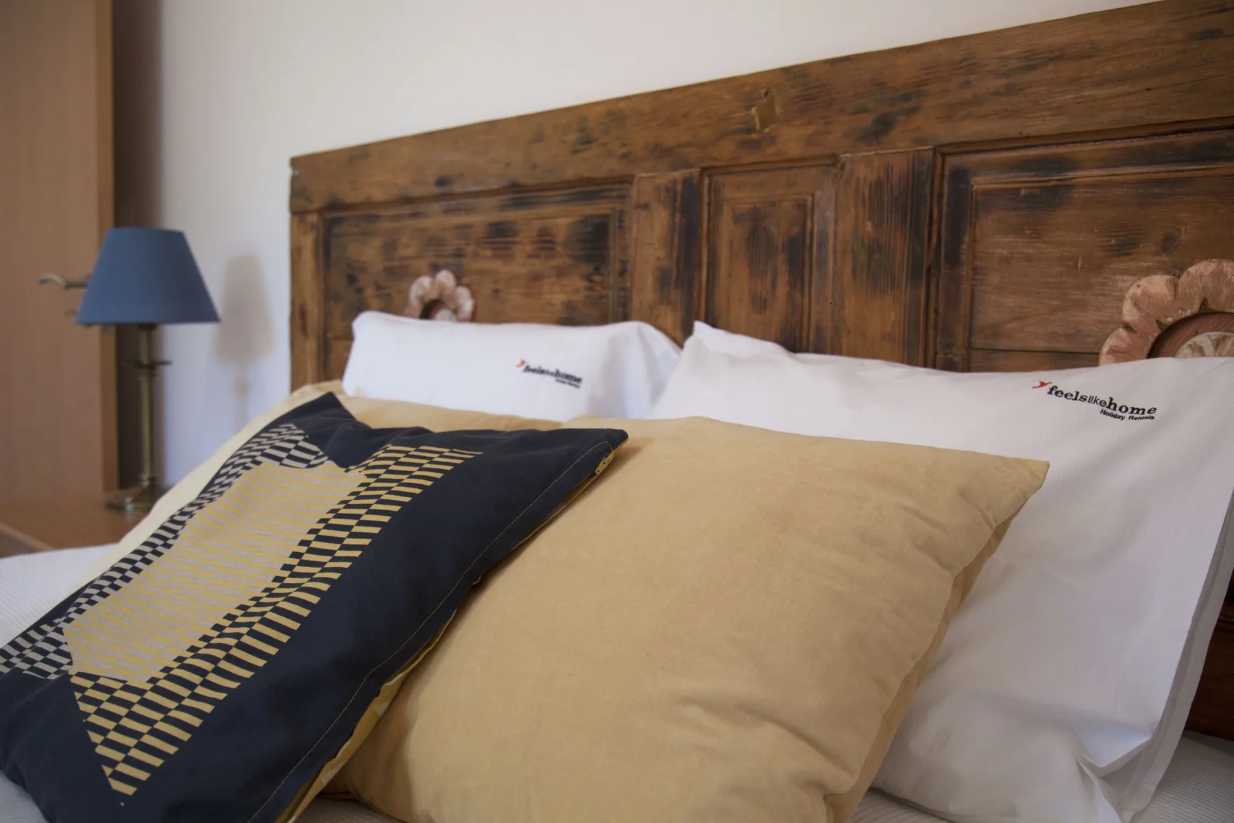 A bedroom with a bed dressed in white linens and decorative pillows.