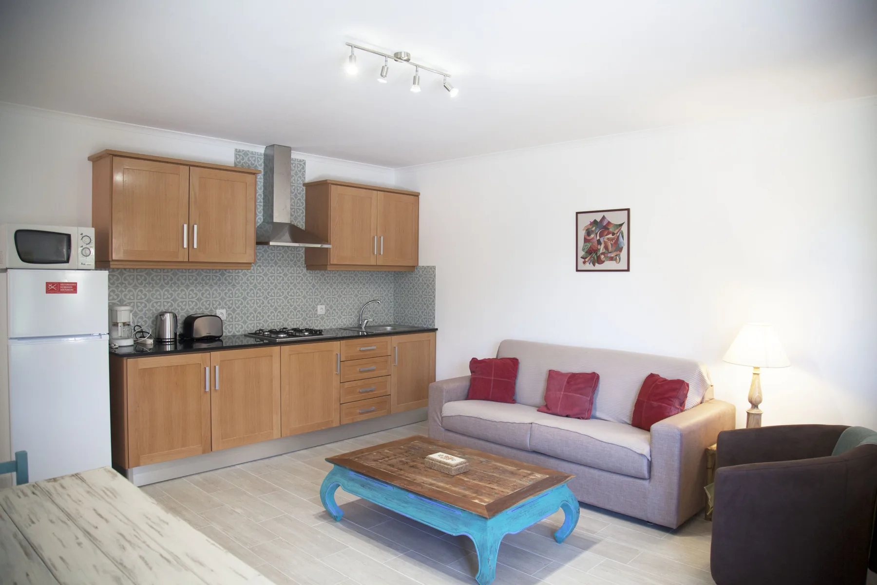A living room with a sofa, coffee table, and adjoining kitchen.