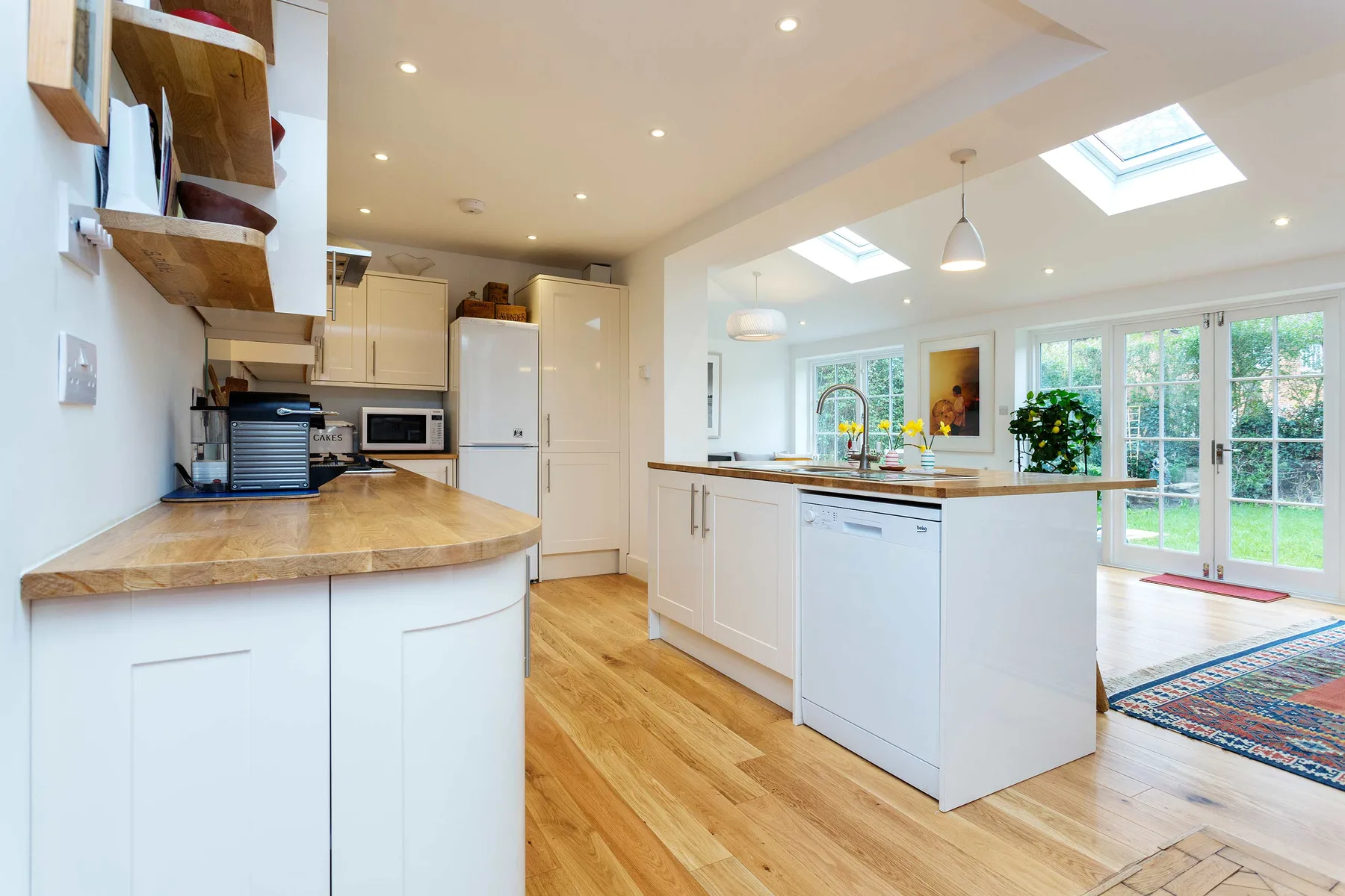 A bright open-plan kitchen with white cabinetry and a central island.