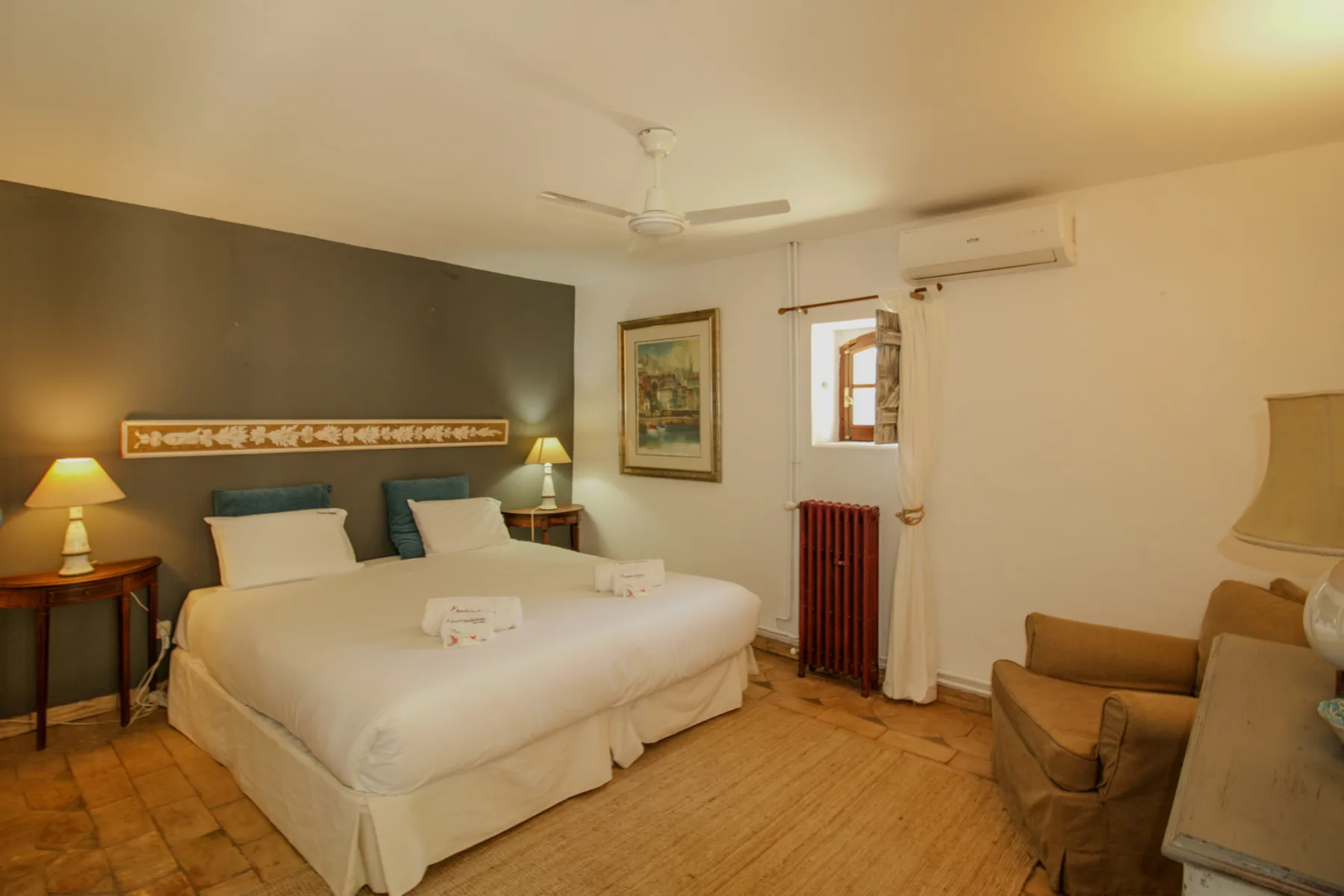 A bedroom with a bed, bedside tables, and an armchair.
