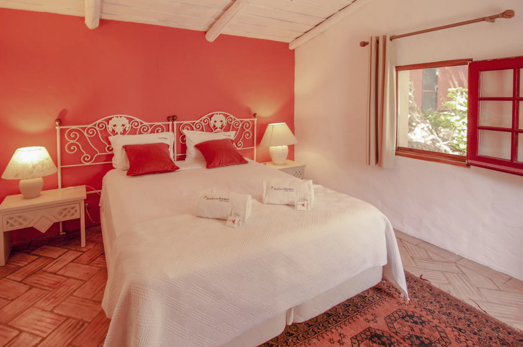 Un dormitorio con una cama grande, mesitas de noche y una ventana.