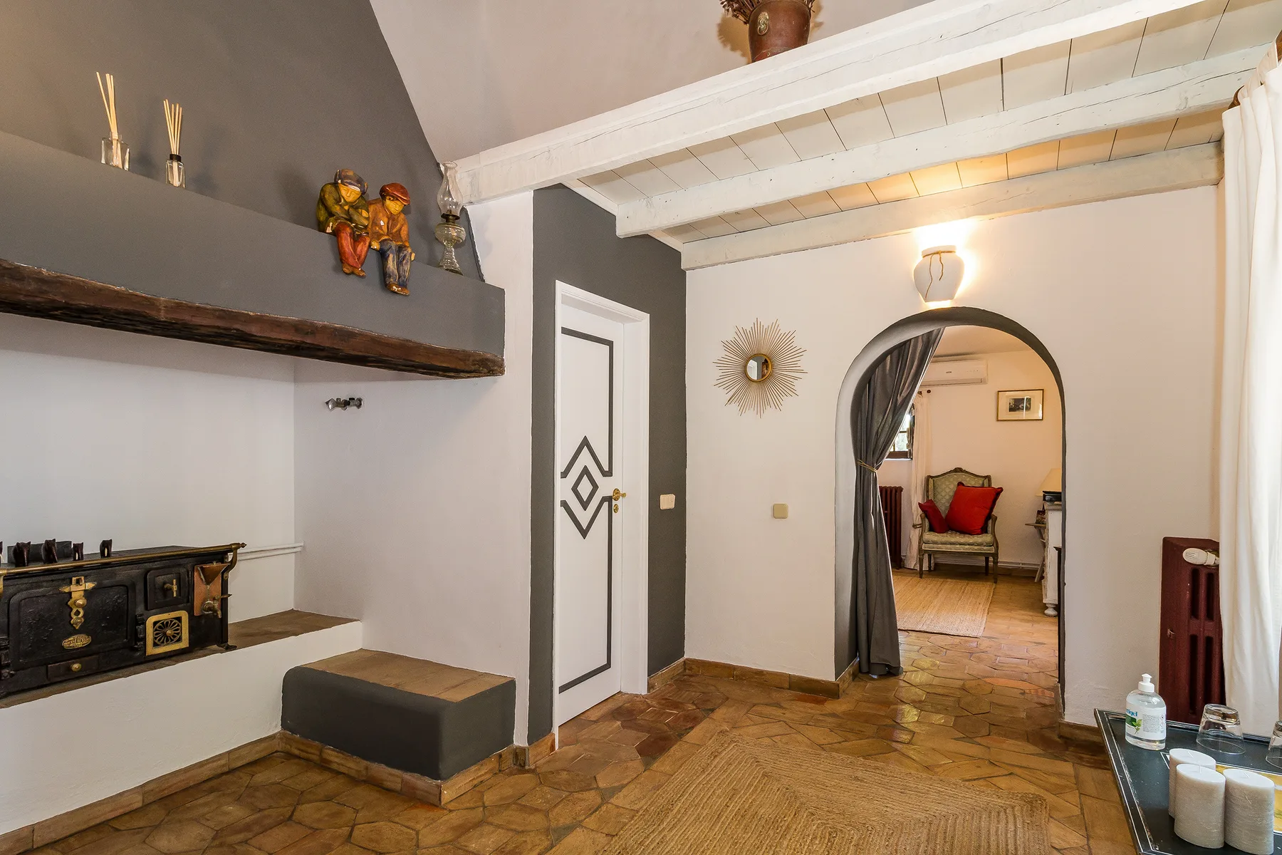 Un pasillo interior con un arco que da a una zona de estar.