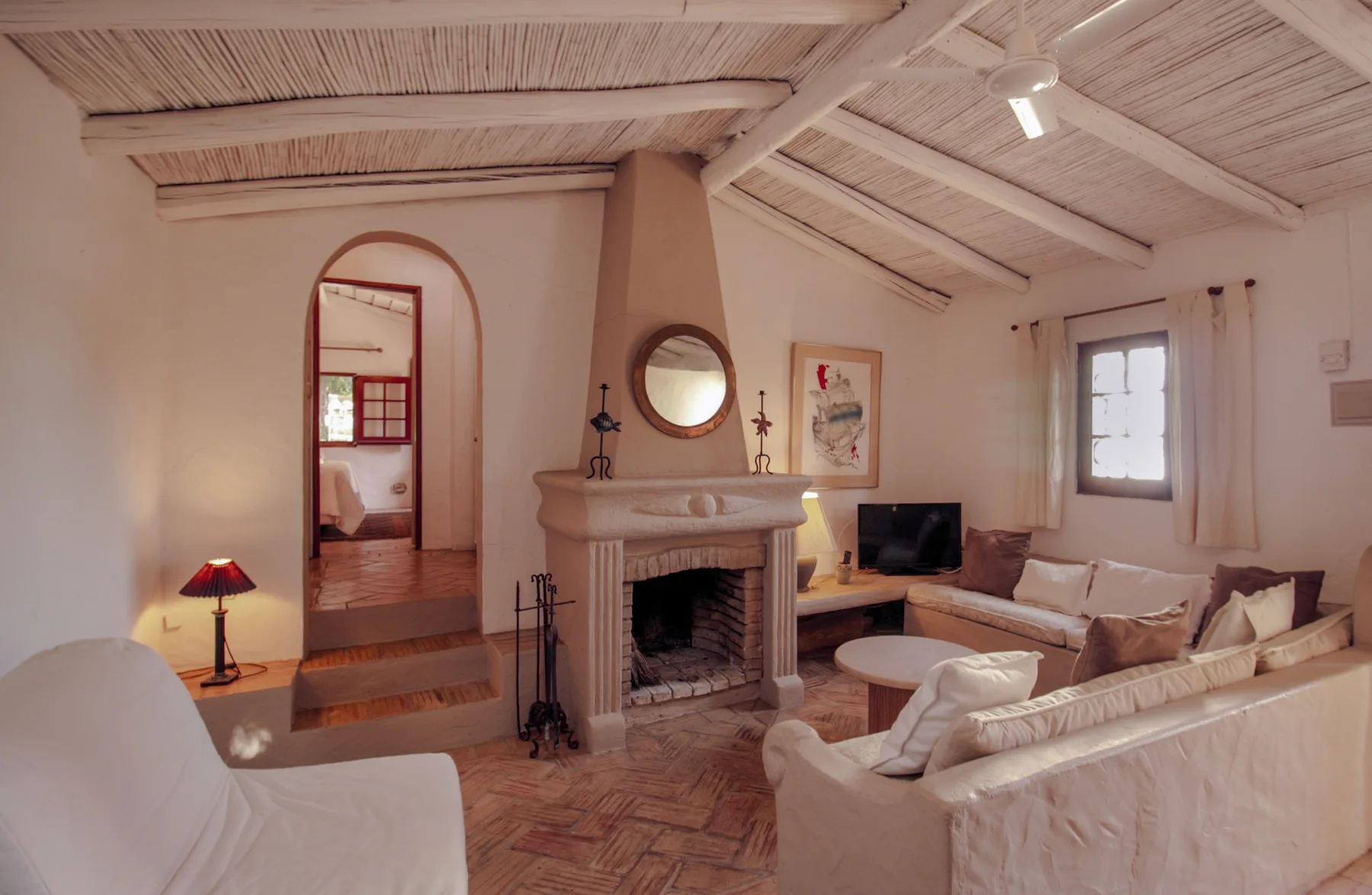 Una sala de estar con asientos dispuestos alrededor de una chimenea.