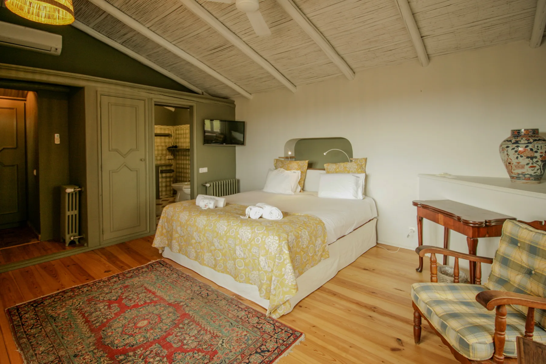 Un dormitorio con una cama doble, una alfombra estampada y muebles de madera.