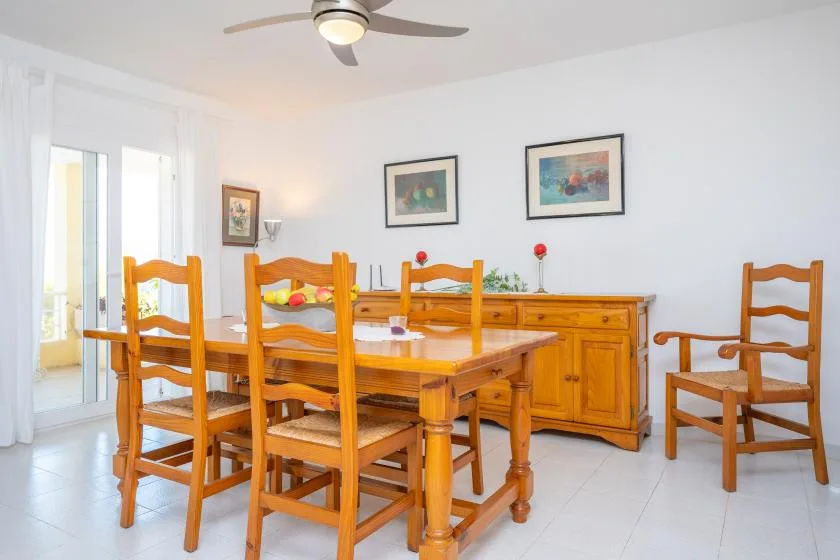 A dining room with a wooden table and chairs beside a sideboard.