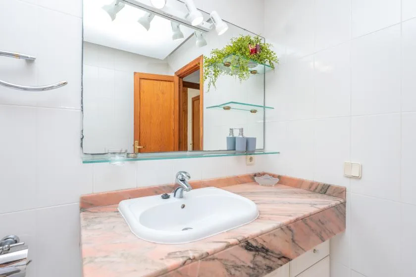 A bathroom vanity with a sink and large mirror.