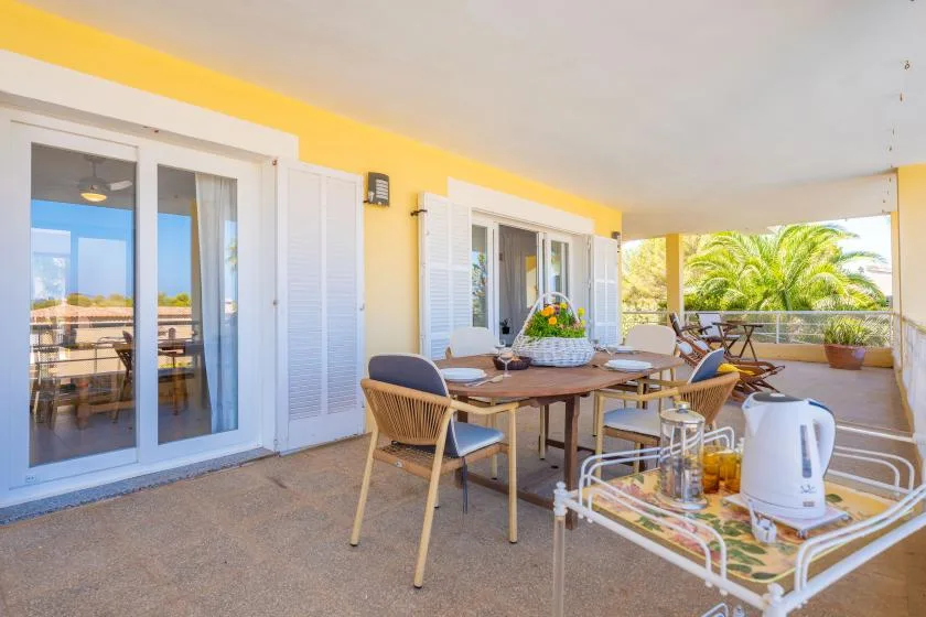 A covered patio dining area with a table and chairs.