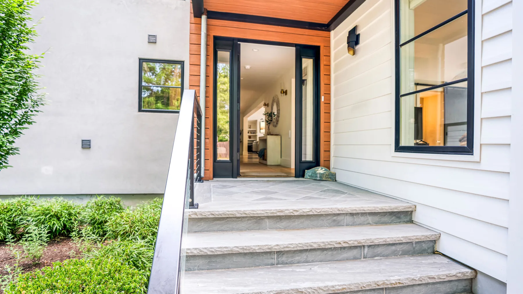 An exterior entry porch with broad steps and a glass door.