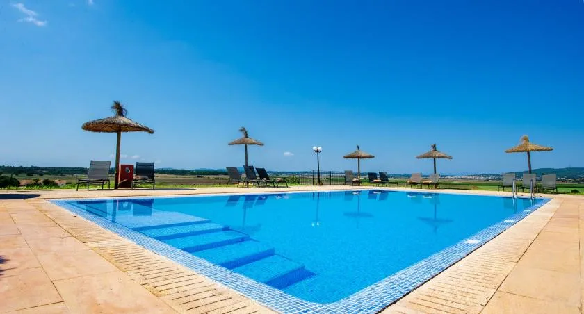 Una piscina al aire libre con escalones y sombrillas alrededor.