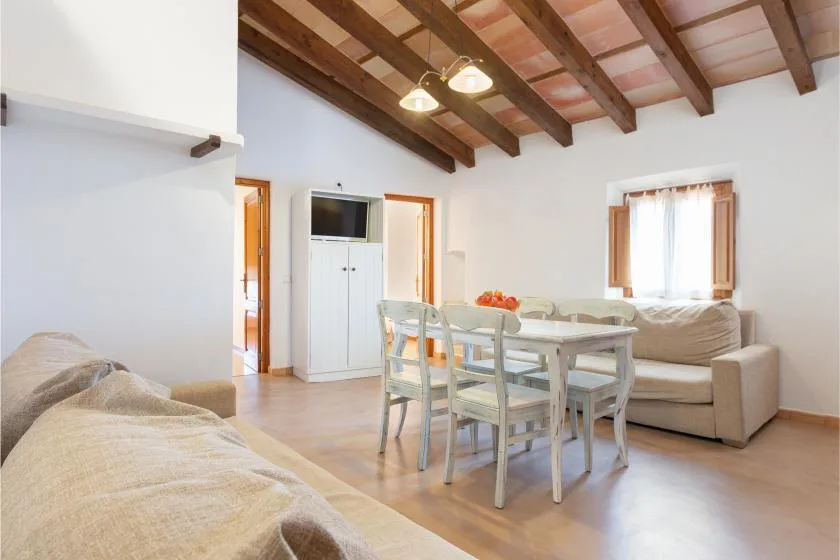 Comedor con mesa y asientos junto a una zona de estar.